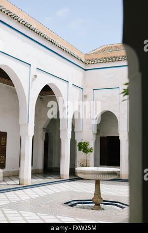 Ein Brunnen in einem kleinen, weißen Innenhof der Bahia-Palast, eine beliebte Touristenattraktion in Marrakesch, Marokko Stockfoto