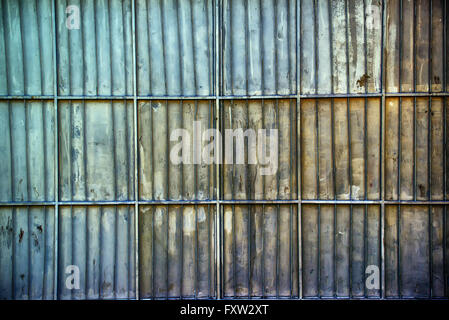 Rusty oxidiert Aluminium Metall einengender Garagenwand, metallische Oberflächenstruktur mit horizontalen und vertikalen Bewehrungsstäbe Stockfoto