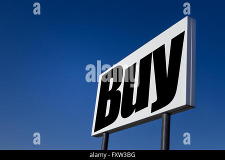 Große Anzeige-Panel, geprägt mit der Meldung "Kaufen", isoliert auf blauen Himmel. Stockfoto