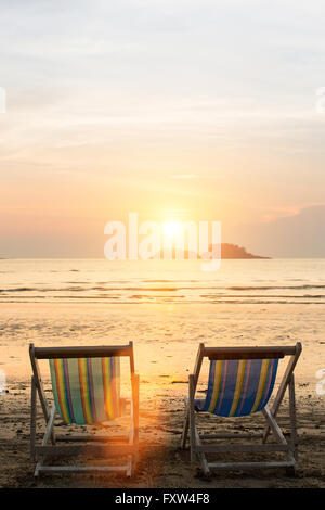 Sonnenliegen am Strand bei Sonnenuntergang. Stockfoto