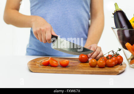 Nahaufnahme von Frau hacken Tomaten mit Messer Stockfoto