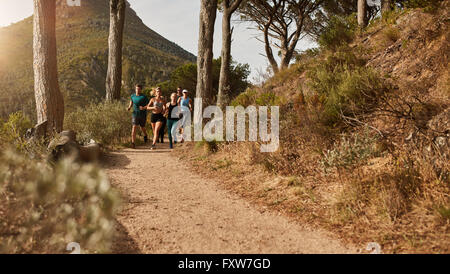 Gruppe von Athleten zusammen laufen durch Wanderwege am Hang. Junge Menschen Trailrunning auf einem Bergpfad im Freien. Stockfoto