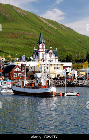 Boot, farbenfrohen Gebäuden und Kirche, Husavik Hafen, Husavik, Island Stockfoto