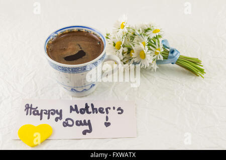 Glückliche Mütter Tag Hinweis mit Tasse Kaffee und Kamille bouquet Stockfoto