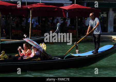 Touristen IN der Gondel mit Sonnenschirm Venedig VENEZIA Italien 1. August 2014 Stockfoto