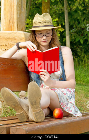 Junge Frau, die ein Buch in der Natur Stockfoto