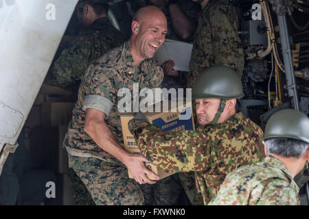 US Marines unterstützen japanische Selbstverteidigung Soldaten entladen humanitäre Hilfe für die betroffenen durch die jüngsten Erdbeben in Kumamoto 18. April 2016 Takayubaru, Japan. Die USA trat Tausende von japanischen Truppen, Opfer von zwei massiven Erdbeben zu helfen, die die Kyushu-Region getroffen. Stockfoto