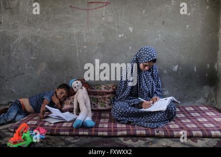 (160419)--GAZA, 19. April 2016 (Xinhua)--17-j hrige palästinensischen Huwaida Al-Zaree (R) versucht, Probleme in ihrem Technologie-Buch vor ihrem Haus in den südlichen Gazastreifen Stadt des Khan Younis, am 17. April 2016 zu lösen. 23. April ist der Welttag des Buches und Copyright-Tag. Es war eine natürliche Wahl für UNESCO Generalkonferenz, gehalten in Paris im Jahr 1995, Tribut zu zahlen ein weltweit zu Büchern und Autoren an diesem Datum, ermutigen alle, und besonders junge Menschen entdecken die Freude am lesen und gewinnen einen erneuten Respekt für die unersetzliche Beiträge derjenigen, die weiteren haben Stockfoto