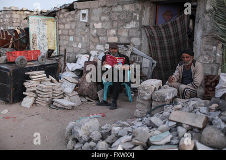 (160419)--GAZA, 19. April 2016 (Xinhua)--palästinensischen Fathi Abu Habib (L), 55, liest Englisch Buch seines Sohnes an seinem Haus in den südlichen Gazastreifen Stadt des Khan Younis, am 17. April 2016. Fathi liest Englisch gut und gerne seine Kinder Englisch zu unterrichten. 23. April ist der Welttag des Buches und Copyright-Tag. Es war eine natürliche Wahl für UNESCO Generalkonferenz, gehalten in Paris im Jahr 1995, Tribut zu zahlen ein weltweit zu Büchern und Autoren an diesem Datum, ermutigen alle, und besonders junge Menschen entdecken die Freude am lesen und gewinnen einen erneuerten Respekt für die unersetzliche nisch Stockfoto