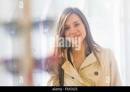 Frau trägt Regenmantel, Blick auf die Kamera zu Lächeln Stockfoto