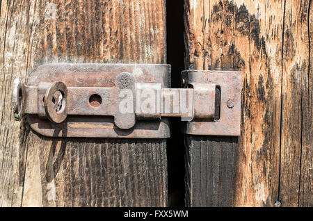 Alte rostige Klinke auf eine Holztür. Stockfoto