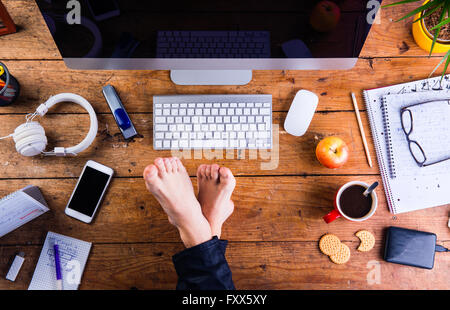 Geschäftsmann, arbeiten in seinem Büro mit Füßen auf Schreibtisch Stockfoto