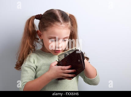 Niedliche überraschend kleines Kind Mädchen auf der Suche in Mutter Brieftasche und wollen Geld mit leere Kopie Platz nehmen Stockfoto