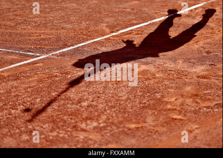 Schatten ein Tennis-Spieler in Aktion auf einem Sandplatz Stockfoto
