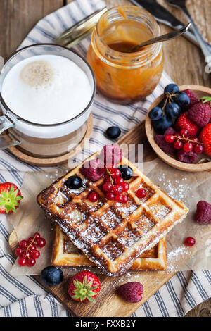 Belgische Waffeln mit frischen Beeren und Cappuccino Kaffee zum Frühstück Stockfoto