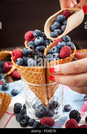 Frische Heidelbeeren, Brombeeren und Himbeeren in Waffelhörnchen Stockfoto