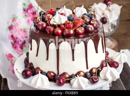 Lecker hausgemachte Kuchen mit Schokolade, Baiser und frischen Beeren verziert Stockfoto