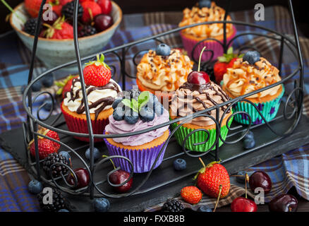 Reihe von verschiedenen leckeren Cupcakes auf dunklen Stockfoto
