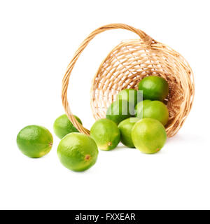 Weidenkorb voller mehrere Reife Limetten, Zusammensetzung, die über dem weißen Hintergrund isoliert Stockfoto