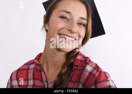 Porträt von Happy Young Girl graduate tragen Kappe. Isoliert auf weißem Hintergrund Stockfoto