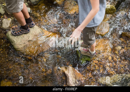 Geringen Teil der Wanderer stehen auf Felsen im stream Stockfoto