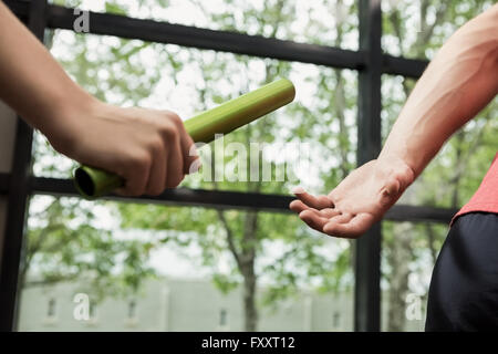 Athlet, vorbei an einem Schlagstock auf dem partner Stockfoto