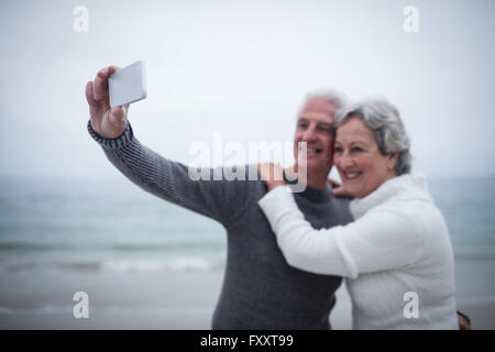 Älteres paar unter einem Selfie am Strand Stockfoto