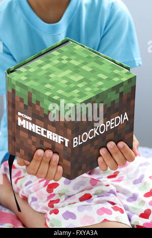 Kleiner Junge liest Minecraft Buch Stockfoto