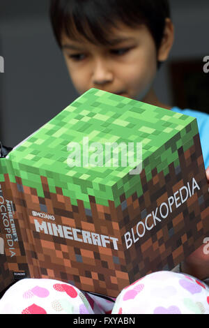 Kleiner Junge liest Minecraft Buch Stockfoto