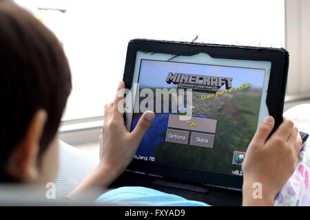 Junges Kind spielen Minecraft Spiele auf dem iPad Stockfoto