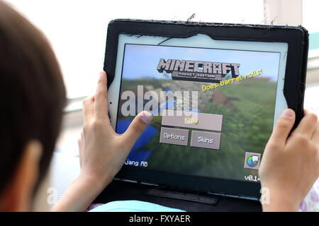 Junges Kind spielen Minecraft Spiele auf dem iPad Stockfoto