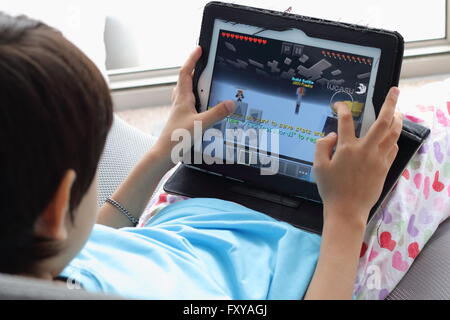 Junges Kind spielen Minecraft Spiele auf dem iPad Stockfoto