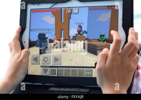 Junges Kind spielen Minecraft Spiele auf dem iPad Stockfoto