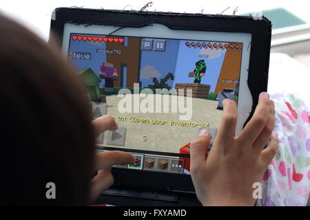 Junges Kind spielen Minecraft Spiele auf dem iPad Stockfoto