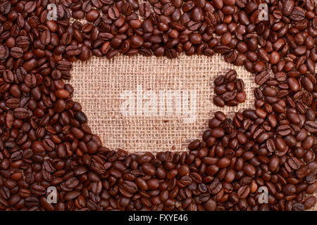 Geröstete Kaffeebohnen mit textfreiraum in Form eines Bechers auf Sackleinen Hintergrund Stockfoto