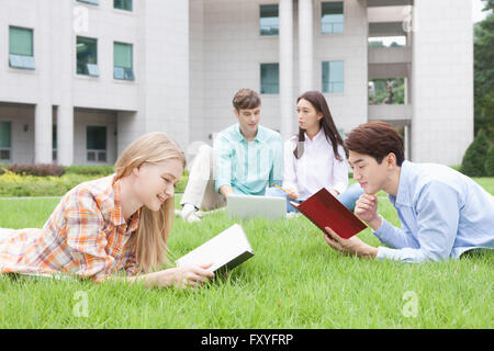 Inländische Studierende und ausländische Studierende in der Schule gemeinsam draußen auf dem Campus studieren Stockfoto