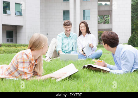Inländische Studierende und ausländische Studierende in der Schule gemeinsam draußen auf dem Campus studieren Stockfoto