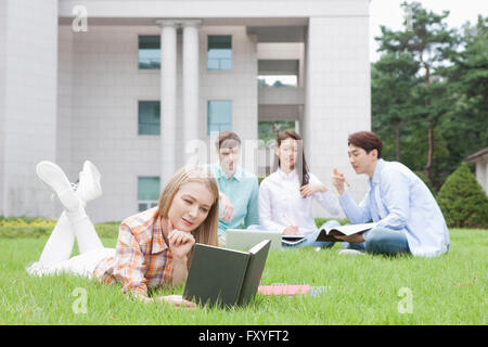 Inländische Studierende und ausländische Studierende in der Schule gemeinsam draußen auf dem Campus studieren Stockfoto