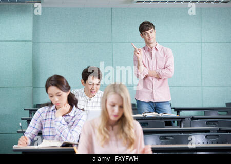College-Studenten bestehend aus nationalen und internationalen Studenten in einem Klassenzimmer auf dem Campus und ein internationaler Student stehend Stockfoto