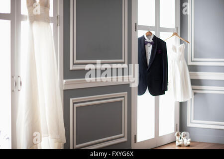 Smoking und zwei Brautkleider hingen bis auf Windows und high heels Stockfoto