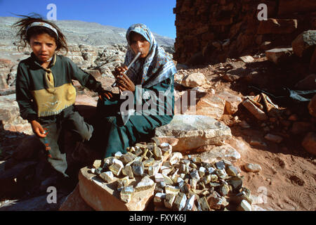 Beduinen-Frau mit ihrer Tochter Verkauf von Steinen und dem Flötenspiel, Petra, Jordanien. Stockfoto