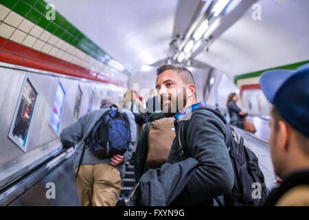 Hipster-Mann stehend auf der Rolltreppe in London u-Bahn Stockfoto