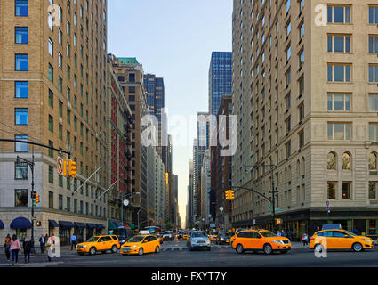 Kreuzung an der 6th Avenue in Midtown Manhattan, New York, USA. Straße zum Central Park South. Schwerlastverkehr auf der Straße, vor allem Taxi Autos. Und viele Touristen vorbei. Stockfoto