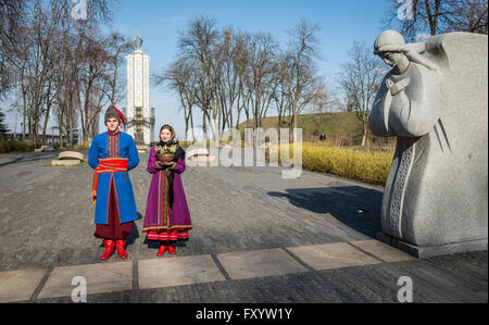 Ukrainischen Mann und Frau tragen Trachten vor Denkmal nach der Holodomor Opfer Kiew, Ukraine Stockfoto