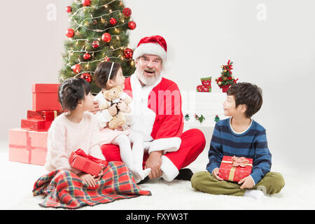 Lächelnden Weihnachtsmann und Kinder sitzen am Boden zu Weihnachten Stockfoto