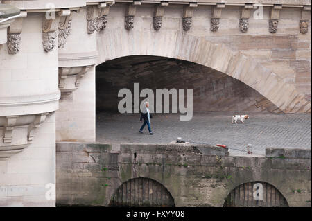 Paris Quai Frau, einer Frau, die zu ihrem Hund auf dem Quai in der Nähe der Pont Neuf, Paris, Frankreich. Stockfoto