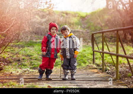 Zwei süße Kinder, junge Brüder, zusammen zu spielen, im Park, ländliches Dorf Umwelt, Frühling, Freiheit-Kindheit-Konzept Stockfoto