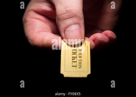 Ein Mann rechten Hand ein gelbes 7-stellige Ticket markiert mit den Worten "THIS TICKET halten" in schwarzer Tinte Stockfoto