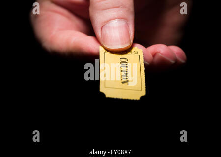 Ein Mann rechten Hand ein gelbes 7-stellige Ticket gekennzeichnet mit dem Wort "Gutschein" schwarze Tinte Stockfoto