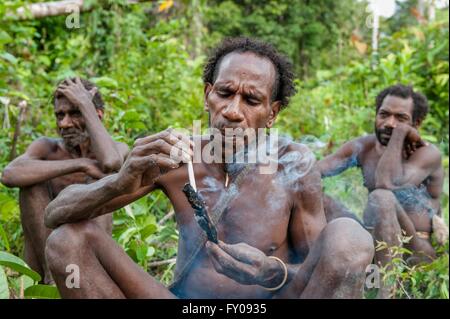 Das Porträt des Menschen von der Korowai Stamm Rauchen. Korowai Kombai (Kolufo). Stockfoto
